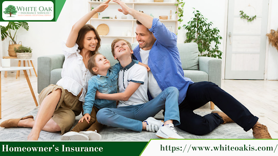 A family of four sitting on the floor of their living room having fun. The mother and father are holding their hands over the children's heads simulating a roof top.